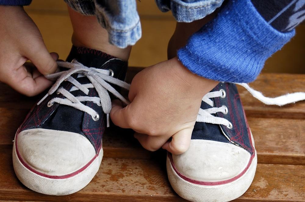copil mic legarea pantofilor