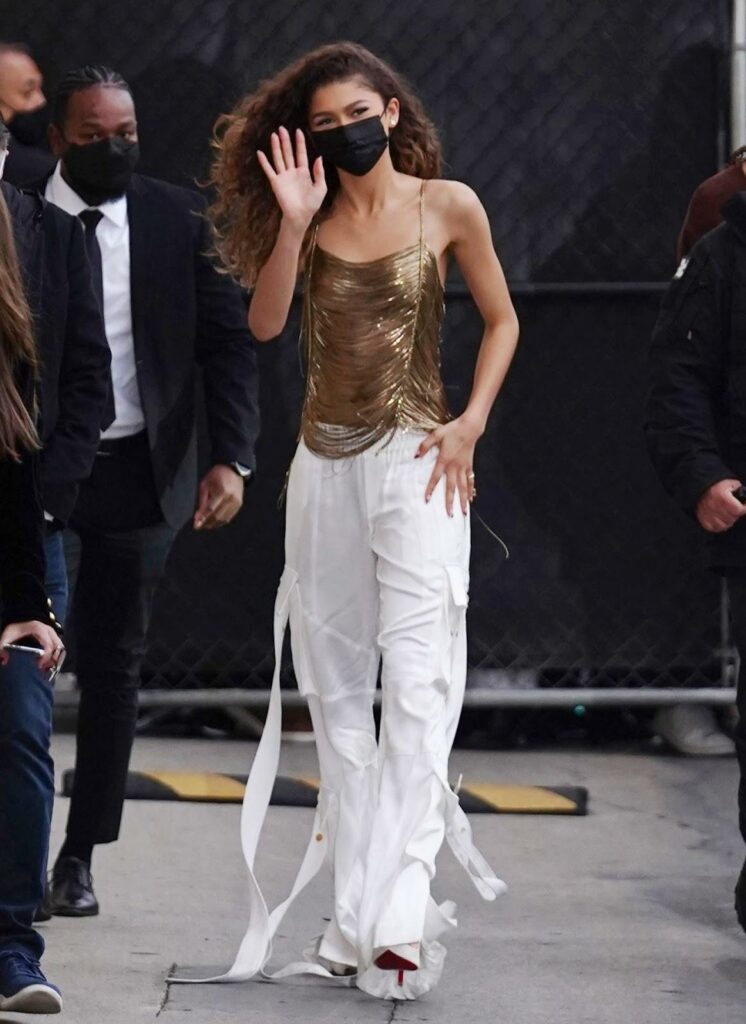 Zendaya cu pantaloni cargo albi, top auriu și pantofi albi cu toc