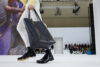 Un model, cu geantă și pantofi negri, pășește pe podium în timpul defilării Loewe Menswear Fall-Winter 2023-2024, în cadrul Săptămânii Modei de la Paris