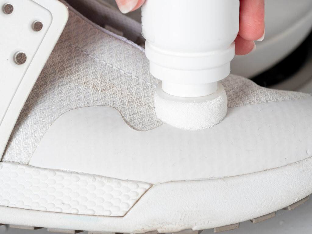 Curățarea unui preparat special cu un burete dintr-un pantof sport alb: detalii
