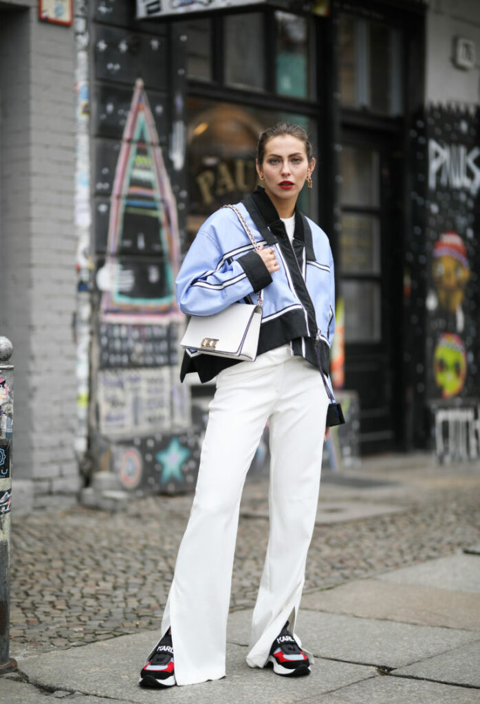Masha Sedgwick (Maria Astor) poartă pantaloni Laurel albi, jachetă Sportmax SS19 albastră, geantă Furla albă, tricou alb Calvin Klein, sneakerși Karl Lagerfeld 
