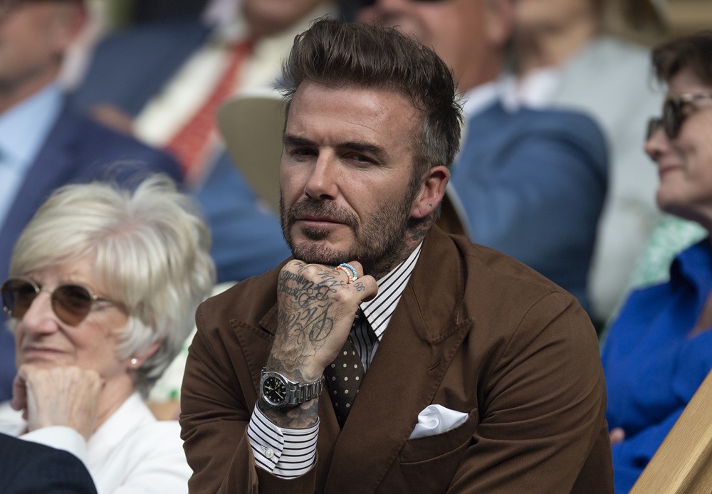 David Beckham poartă un sacou maro și un ceas