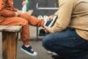 Tatăl pune pantofii de școală pe picioarele copilului